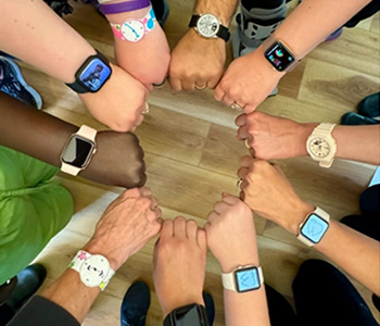 Dental team placing hands together in a circle