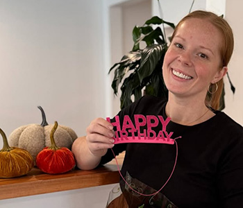 Dental team member holding up a Happy Birthday head-band