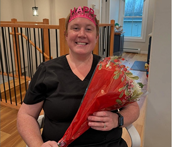 Dental team member holding up a Happy Birthday head-band