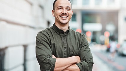 Man smiling outside office building