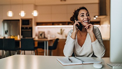 Woman smiling while talking on phone at home