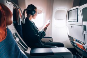 a woman looking at her phone on an airplane