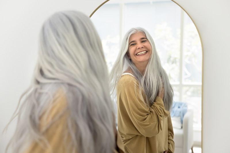 Older patient smiling with their Invisalign aligners